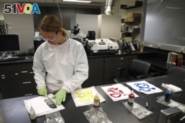 In this June 27, 2019 photo, physical scientist Ashley Wright creates sample sheets from different colors of inkjet printer ink in the International Ink Library at the U.S. Secret Service headquarters building in Washington, DC.