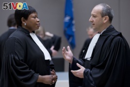 Emmanuel Altit (R) defense lawyer of Former Ivory Coast president Laurent Gbagbo talks to prosecutor Fatou Bensouda (L) as they wait for the start of Gbagbo trial at the International Criminal Court in The Hague on January 28, 2016.