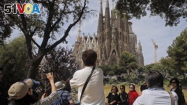 In this Thursday, May 26, 2016 file photo, tourists take pictures in front of Sagrada Familia church, designed by architect Antoni Gaudi in Barcelona, Spain. (AP Photo/Manu Fernandez, File)