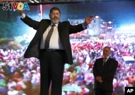 In this May 20, 2012 file photo, then Muslim Brotherhood's presidential candidate Mohammed Morsi holds a rally in Cairo, Egypt. (AP Photo/Fredrik Persson, File)