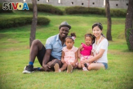 Lily Lee, far right, sits with her family for a portrait. Pictured: James, far left, with their daughters Yuri, center left, and Dasomi, center right.