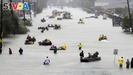 FILE - Rescue boats float on a flooded street as people are evacuated from rising floodwaters brought on by Tropical Storm Harvey on Aug. 28, 2017, in Houston, Texas.