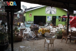 FILE - Damaged chairs and tables lie among the debris strewn after a bomb attack outside an Ethiopian restaurant in Kampala, Uganda, July 12, 2010.