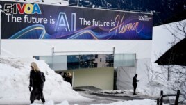 FILE - An advertising banner with a slogan about AI is fixed at a building at the Davos Promenade, alongside the World Economic Forum in Davos, Switzerland, Jan. 18, 2024. (AP Photo/Markus Schreiber, File)