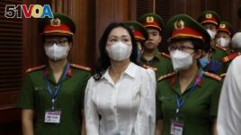 Vietnamese real estate tycoon Truong My Lan, front center, is escorted into a courtroom in Ho Chi Minh city, Vietnam, Tuesday, March 5, 2024. (Phan Thanh Vu/VNA via AP)