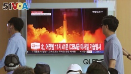 In this Saturday, July 29, 2017 photo, People watch a TV news program showing an image of North Korea's latest test launch of an intercontinental ballistic missile (ICBM), at the Seoul Railway Station in Seoul, South Korea. 