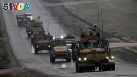 FILE - A convoy of US military vehicles is seen in Syria's northern city of Manbij, Dec. 30, 2018.