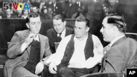 John Dillinger (center) was Public Enemy No. 1 in the 1930s. Here he is handcuffed and guarded in court as his trial date is set for March 12 at Crown Point, Ind., Feb. 9, 1934. (AP PHOTO)