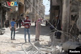 Residents inspect damages after an airstrike on the rebel held al-Maysar neighborhood in Aleppo, Syria, April 11, 2016. 