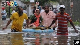 An elderly Sri Lankan woman is shifted on a makeshift raft at a flooded area in Colombo, Sri Lanka, Tuesday, May 17, 2016. The Disaster Management Center said that 114 homes have been destroyed and more than 137,000 people have been evacuated to safe locations as heavy rains continue. (AP Photo/Eranga Jayawardena)