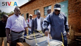 Burundian president Pierre Nkurunziza, right, casts his vote at a polling station in his hometown of Mumba in Ngozi province, northern Burundi. After all the opposition parties pulled out of the race, the voters have only the choice between the ruling CND