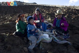 The Pacco family eats dinner after harvesting potatoes in Paru Paru, in the Cusco region of Peru, May 26, 2016.