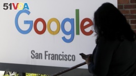 In this May 1, 2019, file photo, a person walks past a Google sign in San Francisco. (AP Photo/Jeff Chiu, File)
