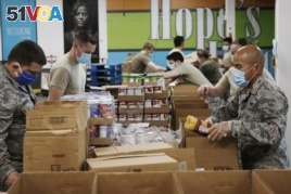 Airman First Class Binh Pham, right, and other members of the Oklahoma Air National Guard fill emergency food boxes at the Regional Food Bank Thursday, April 23, 2020, in Oklahoma City.