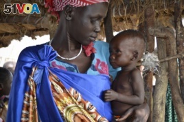 Elizabeth Nyakoda holds her severely underfed 10-month old daughter at the feeding center for children in Jiech, Ayod County, South Sudan. (Sam Mednick/AP)