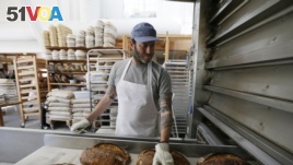 Nothing beats warm bread and butter! In this photo, baker Chad Robertson checks loaves of bread coming out of an oven at the Tartine Manufactory in San Francisco, California, 2017. (AP Photo/Eric Risberg)