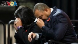 University of Virginia Athletic Director Carla Williams, left, and football coach Tony Elliott wipe tears from their eyes during a memorial service for three slain University of Virginia football players in Charlottesville, Va., Nov. 19, 2022. (AP Photo/Steve Helber, Pool)