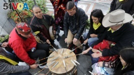Native Americans and First Nations people join in on a drum circle during an Indigenous Peoples Day blessing and rally before a march Monday, Oct. 8, 2018, in Seattle. (AP Photo/Elaine Thompson)