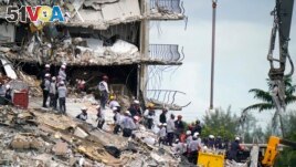 Rescue workers search in the rubble at the Champlain Towers South condominium, Monday, June 28, 2021, in the Surfside area of Miami. (AP Photo/Lynne Sladky)