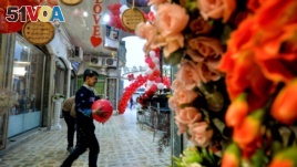 Children play with red balloons that are part of Valentine's day decorations at a shopping mall in Iraq's northern city of Mosul on February 13, 2020. (Photo by Zaid AL-OBEIDI / AFP) 