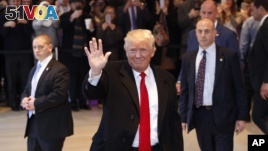 President-elect Donald Trump waves to the crowd as he leaves the New York Times building following a meeting, Nov. 22, 2016, in New York.