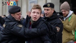 FILE - Belarus police detain reporter Raman Pratasevich, center, in Minsk, March 26, 2017.