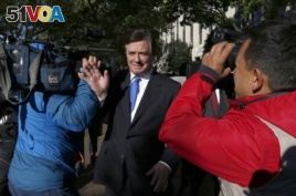 Paul Manafort makes his way through television cameras as he walks from Federal District Court in Washington, Oct. 30, 2017.