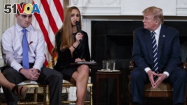 From left, Marjory Stoneman Douglas High School students Jonathan Blank and Julia Cordover, and President Donald Trump participate in a listening session with high school students, teachers, and others at the White House in Washington, Wednesday, Feb. 21, 2018. (AP Photo/Carolyn Kaster)