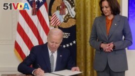 U.S. President Joe Biden signs an Executive Order about Artificial Intelligence as Vice President Kamala Harris looks on, in the East Room at the White House in Washington, U.S., October 30, 2023. (REUTERS/Leah Millis)