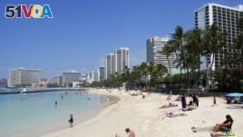 In this Monday, March 13, 2017 photo, people relax on the beach in Waikiki in Honolulu. (AP Photo/Caleb Jones)