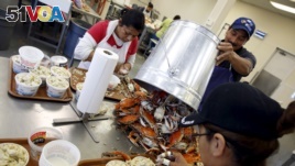 Mexican workers, on the U.S. H2B visa program for seasonal guest workers, process crabs at the A.E. Phillips & Son Inc. crab picking house on Hooper's Island in Fishing Creek, Maryland, Aug. 26, 2015.