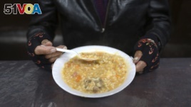A man eats his soup during 
