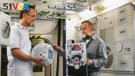 CIMON project manager Till Eisenberg (left) and Josef Sommer, CIMON GNC Team Leader at Airbus, are testing CIMON with images of Astronaut Alexander Gerst. (Airbus)
