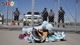 FILE- Shoes and a teddy bear, brought by a group of U.S. mayors, are piled up outside a holding facility for immigrant children in Tornillo, Texas, near the Mexican border, June 21, 2018.