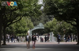 FILE - People walk in front of Sather Gate on the University of California at Berkeley campus in Berkeley, Calif., Thursday, July 18, 2019.