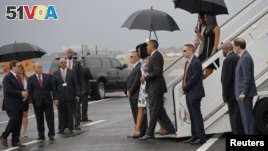 U.S. President Barack Obama and his wife Michelle approach Cuba's foreign minister Bruno Rodriguez as they arrive at Havana's international airport, March 20, 2016. 