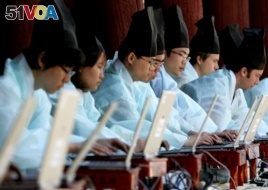 FILE - South Koreans in traditional scholar costumes use laptops at the digital version of a state examination, which were carried out during the Chosun Dynasty, at Sungkyunkwan University in Seoul May 14, 2006.