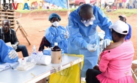 FILE - A Congolese health worker administers Ebola vaccine to a woman who had contact with an Ebola sufferer in the Democratic Republic of Congo, Aug. 18, 2018.