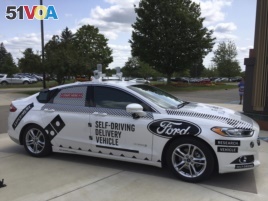 FILE - An Aug. 24, 2017, photo, shows the specially designed delivery car that Ford Motor Co. and Domino's Pizza will use to test self-driving pizza deliveries, at Domino's headquarters in Ann Arbor, Michigan.
