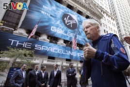 Sir Richard Branson, right, founder of Virgin Galactic, and company executives gather for photos outside the New York Stock Exchange before his company's IPO, Monday, Oct. 28, 2019.