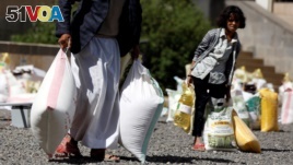 A young woman carries food received from a local charity during the holy month of Ramadan in Sanaa, Yemen, May 29, 2017. 