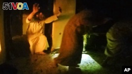 This image made from video taken on Thursday, Oct. 22, 2015 from a helmet camera, shows U.S. and Iraqi special forces freeing hostages from a prison controlled by Islamic State militants.