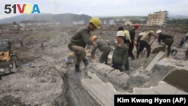 Workers recover cement blocks from flood-damaged areas in Onsong, North Hamgyong Province, North Korea.