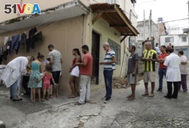 In this March 3, 2018 photo, residents stand in line to receive a free vaccine against yellow fever on the outskirts of Sao Paulo, Brazil.