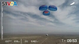 In this image from video made available by Blue Origin, the New Shepard capsule uses parachutes to land during a test in West Texas on Wednesday, April 14, 2021. (Blue Origin via AP)