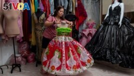 Leonora Buenviaje shows a dress made of used sacks of rice and plastic bags, at her shop in Cainta in the Philippines on March 3, 2022. (REUTERS/Lisa Marie David)