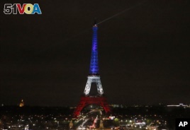 The Eiffel Tower is illuminated in the French national colors red, white and blue in honor of the victims of the terror attacks last Friday in Paris, Monday, Nov. 16, 2015.