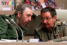 In this file picture taken on December 20, 1999 Cuban President Fidel Castro (L) confers with his brother Raul Castro