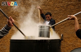 Volunteers cook soup called 'porciuncula' during a religious activity at the convent of Los Descalzos, in Lima, Peru, August, 2017.