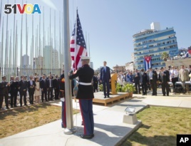 Secretary of State John Kerry and others watch as U.S. Marines raise the U.S. flag over the newly reopened embassy in Havana, Cuba.